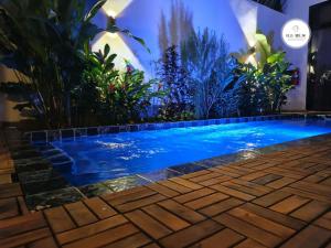 a swimming pool in the middle of a garden at Villa NDOL'AM in Ebomé