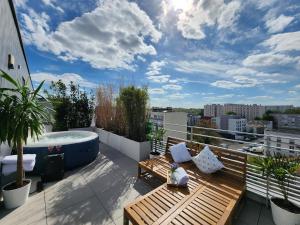 a balcony with a hot tub and wooden benches at Penthouse 166 m2- Terrasse & Parking - Paris Sud - Orly - Parc Expo in Bagneux