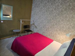a bedroom with a bed with a red blanket at Portela Room in Carnaxide