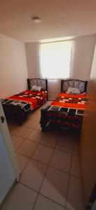 two beds sitting in a room with a window at Bello Amanecer in Guanajuato