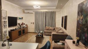 a living room with a couch and a tv at Maison Verde Madinaty in Cairo +9 photos