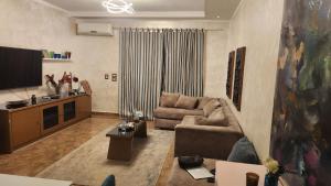 a living room with a couch and a tv at Maison Verde Madinaty in Cairo