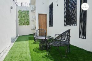 a room with three chairs and a table with green grass at Villa NDOL'AM in Ebomé