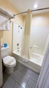 a bathroom with a white toilet and a shower at Citrus Inn & Suites in Porterville