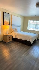 a bedroom with a large bed and a night stand at Citrus Inn & Suites in Porterville