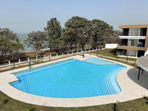 a large blue swimming pool in front of a building at Tanji Cliffs in Tanji