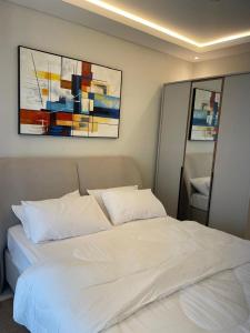 a white bed with two pillows in a bedroom at Tanji Cliffs in Tanji +20 photos