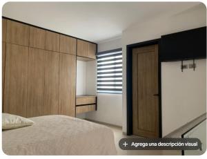 a bedroom with a bed and a wooden cabinet at Complejo Las Flores departamento 3 in Durango