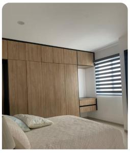 a bedroom with a bed and a wooden wall at Complejo Las Flores departamento 3 in Durango