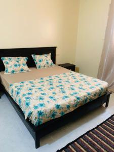 a bedroom with a bed with blue flowers on it at Maison yassine in Douz +6 photos