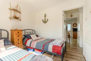 two beds in a room with white walls and wooden floors at 2 Bed in Brixham oc-57244 in Brixham