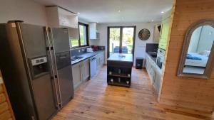 a kitchen with a stainless steel refrigerator and wooden floors at Le Chalet de Merlimont in Merlimont