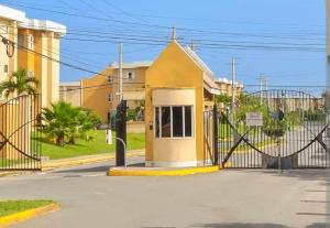 a yellow house with a gate on a street at Leemclean gated vacation home in Spanish Town