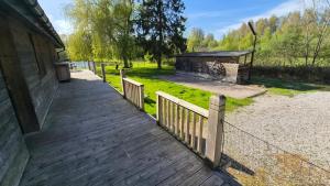 a wooden walkway next to a building with a fence at Le Chalet de Merlimont in Merlimont