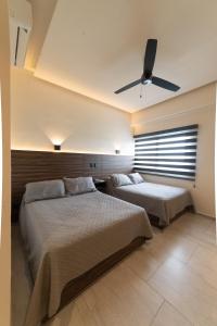 a bedroom with two beds and a ceiling fan at Hotel Melanie Tepic in Tepic +43 photos