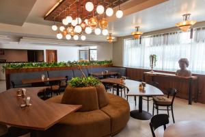 a restaurant with tables and chairs and a large couch at Hotel Melanie Tepic in Tepic