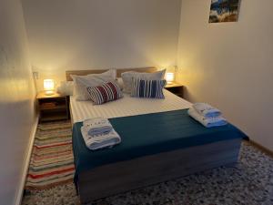 a bedroom with a bed with two towels on it at Căsuțele Allora in Murighiol +20 photos