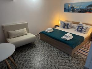 a small bedroom with a bed and a chair at Căsuțele Allora in Murighiol