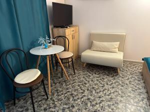 a room with a table and chairs and a tv at Căsuțele Allora in Murighiol