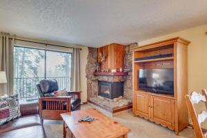 a living room with a tv and a fireplace at Winter Park Condo w/ Pool + Ski Shuttle Access! in Winter Park