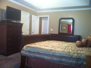 a bedroom with a bed and a dresser and a mirror at Manley Lodge in Locust Grove