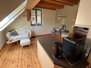 a kitchen and living room with a couch and a television at Forsthaus Boberow in Rheinsberg