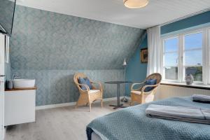 a bedroom with a bed and a table and chairs at Klithuset in Henne Strand