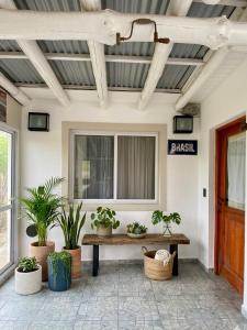 a porch with a bench and plants and a sign at BARRIO VIEJO in Los Reartes