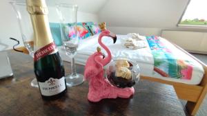 two pink flamingos sitting on a table next to a bed at Birken Loft am Meer in Neustadt am Rübenberge