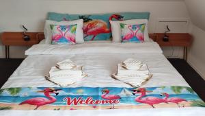 a bedroom with a bed with a pink flamingos blanket at Birken Loft am Meer in Neustadt am Rübenberge