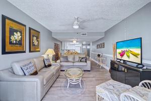 a living room with a couch and a tv at Madeira Place 205 in St. Pete Beach