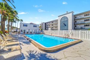 a swimming pool with lounge chairs next to a building at Madeira Place 205 in St. Pete Beach