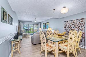 a dining room and living room with a table and chairs at Madeira Place 205 in St. Pete Beach