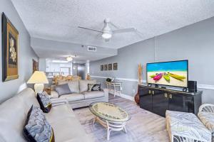 a living room with a couch and a tv at Madeira Place 205 in St. Pete Beach +17 photos