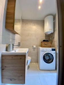 a bathroom with a washing machine and a sink at Kryształowa 47/7 in Piechowice