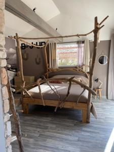 a bedroom with a bed made out of logs at Le petit cabanon in Lagorce