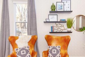 a room with two orange chairs and a window at Expansive Essential Triplex near T in Boston