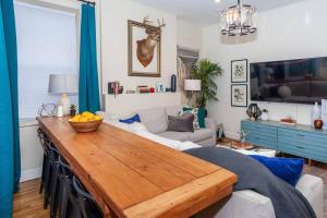 a living room with a table and a couch at Expansive Essential Triplex near T in Boston