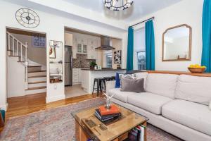 a living room with a white couch and a table at Expansive Essential Triplex near T in Boston