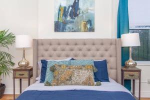 a bedroom with a bed with blue sheets and two lamps at Expansive Essential Triplex near T in Boston +38 photos