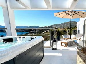a bath tub on a patio with a view of the ocean at Allure villa in Porto Rafti