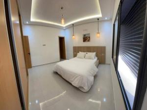 a bedroom with a white bed and a window at Apparemment in Agadir