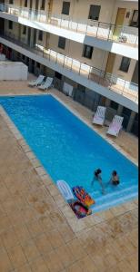 two people are swimming in a swimming pool at Island Dream Apartment in Olhão