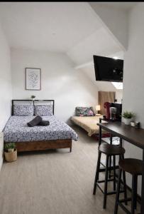 a bedroom with a bed and a table and a desk at Superbe studio top emplacement in Villeneuve-Saint-Georges