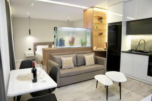 a living room with a couch and a fish tank at Potka Apartments Tirane in Yzberishti