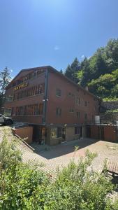 a large brown building with a lot of windows at Çam Otel 2 in Uzungöl