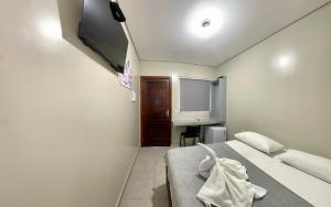 a small room with a bed and a tv at Hotel Colina Verde in Lucas do Rio Verde