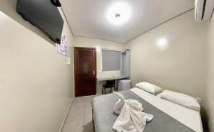 a bedroom with a bed and a desk in it at Hotel Colina Verde in Lucas do Rio Verde