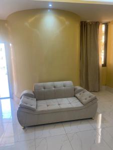 a couch sitting in a room with a yellow wall at Apparthotel Le SALY Beach yenne in Toubab Dialaw
