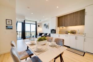 a kitchen and dining room with a table and chairs at Modern Penthouse in Central KW in Kitchener +32 photos